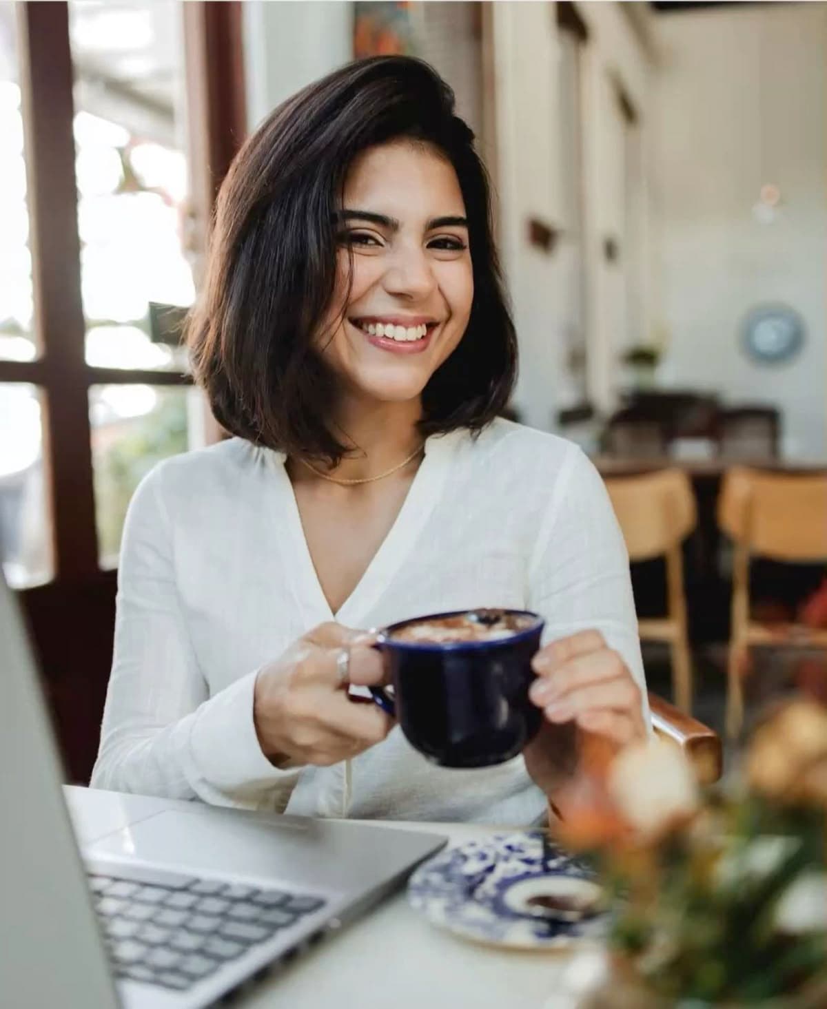 Corretora sorrindo enquanto trabalha, refletindo a parceria da Dabar com corretores e imobiliárias.